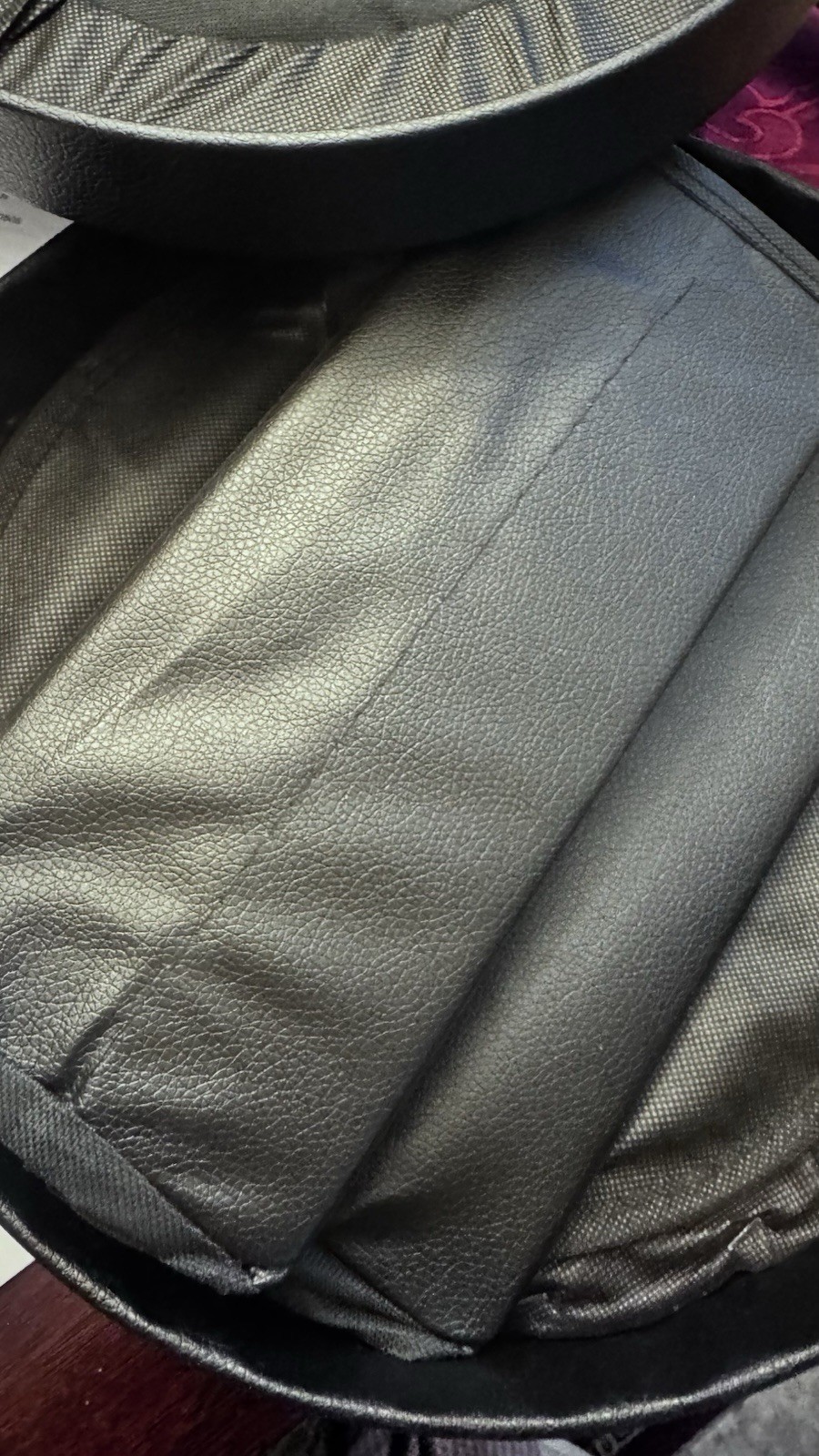 Portable Toilet: This black, circular zippered case is designed t To Hold It.